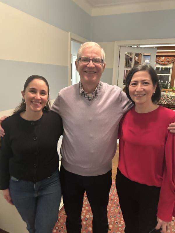 Carney Mimms, standing between Dr. Flavia Golden and Dr. Flavia Fioretti, who saved his life in Central Park, during a holiday celebration at Golden's Upper West Side home with snow falling in the background