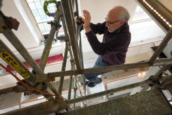 Co<em></em>nservator Gianfranco Pocobene descending from scaffolding after restoring 300-year-old painted angels on the walls of Old North Church in Boston