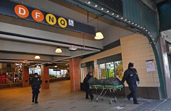 Police wheel out the subway fire victim on a gurney