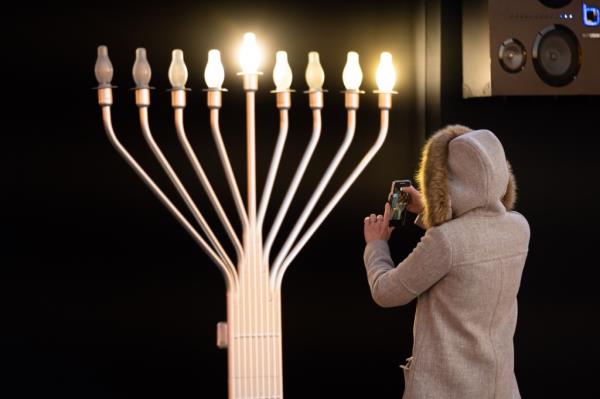 A person takes a photo of the menorah in the Hudson Yards during the first night of Hanukkah on December 10, 2020 