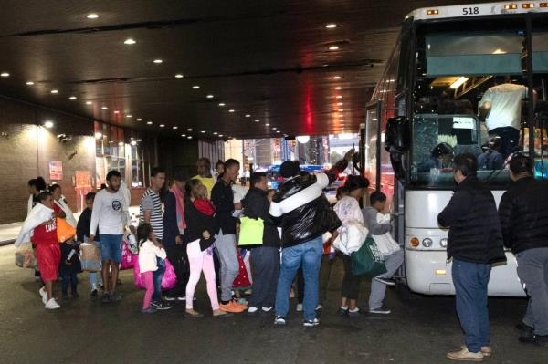 Migrants getting on a bus.