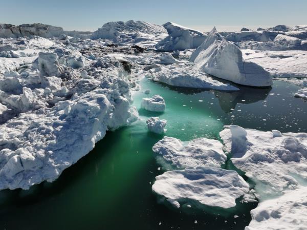 Aerial view of melting icebergs crowding the Ilulissat Icefjord in Greenland, indicative of global warming effects