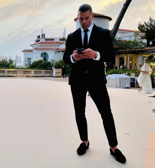 Miguel Angel Aguilar in a suit on his phone.