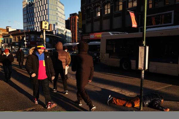 A man passed out on the sidewalk by a bus stop on Dec. 13, 2024.