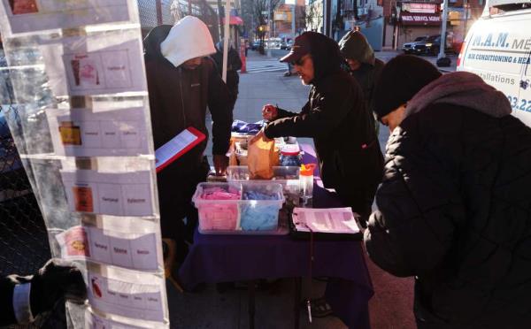 Volunteers with St. Ann's Corner of Harm Reduction passing out clean needles, naloxone kits to reverse an overdose and other supplies in The Hub on Dec. 13, 2024.