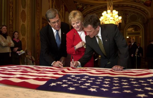 Granger, Trent Lott, and Tom Daschle sign the border of an American flag on Capitol Hill Tuesday, Oct. 2, 2001, 