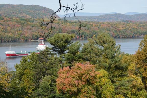 A boat on the Hudson River with fall foliage in the background, seen from the Vanderbilt Mansion in Hyde Park, NY