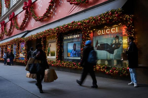 Pedestrians carrying shopping bags walking past the Macy's flagship store in Herald Square, New York ahead of the 2023 US holiday season