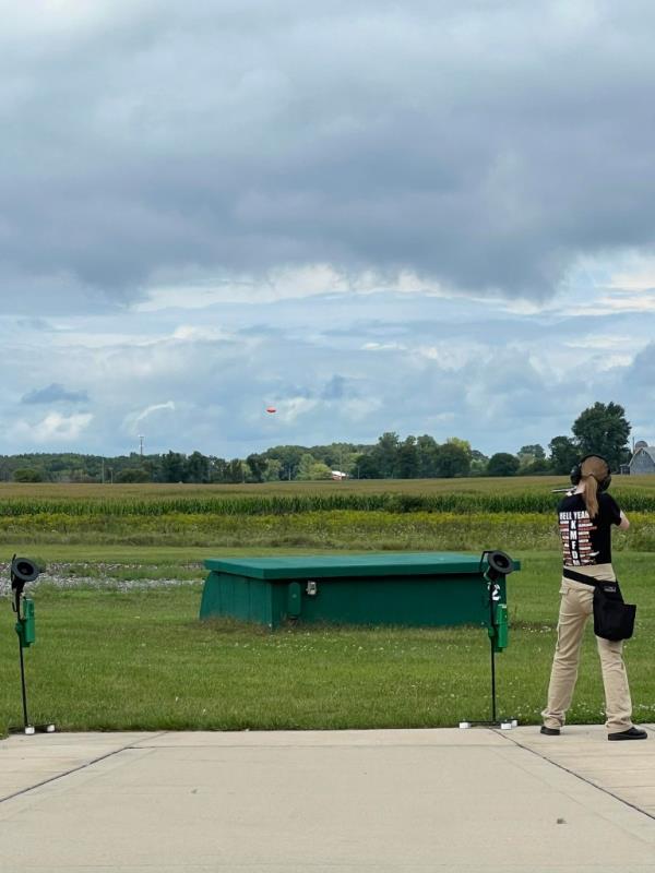 Natalie Rupnow at a shooting range wearing a shirt from the German band KMFDM.