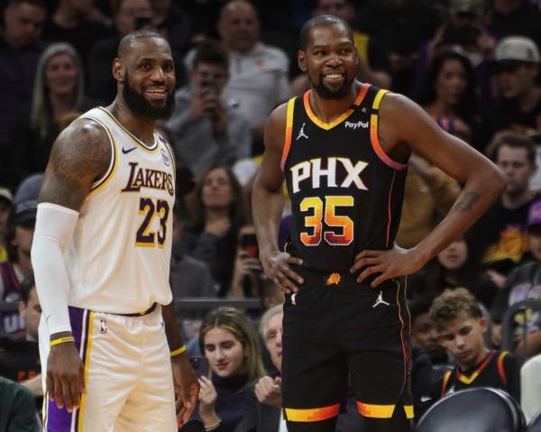 LeBron James #23 of the Los Angeles Lakers and Kevin Durant #35 of the Phoenix Suns look on during the game on November 26, 2024 at Footprint Center in Phoenix, Arizona. 