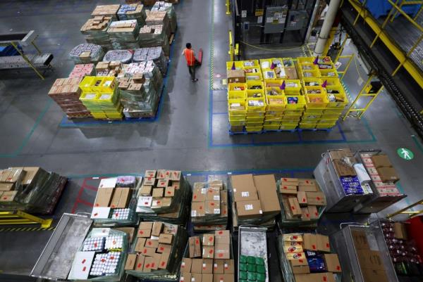 A worker standing amid stacks of products in Amazon's fulfillment center during Cyber Monday