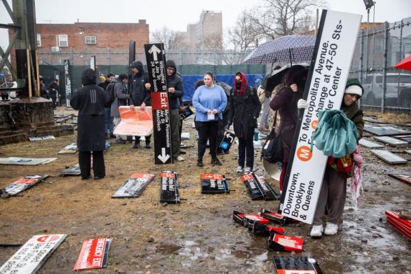 Customers wait in line in the rain and mud to pay for their items at the sale on Monday