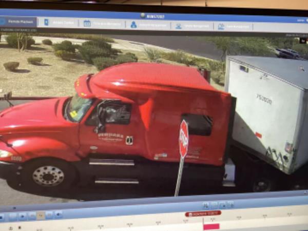 Red truck exiting a warehouse in Las Vegas, captured by surveillance, involved in a scam of stolen holiday goods